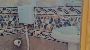Un baño con inodoro, bidé y lavamanos.