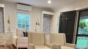 A living room with a bed, two armchairs, a coffee table, and a large window with blinds. - Richmond Near West End, Charming Private Cottage (Richmond)