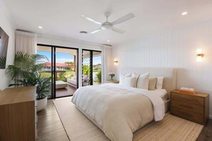 Ein Schlafzimmer mit Bett, Nachttisch und Deckenventilator.