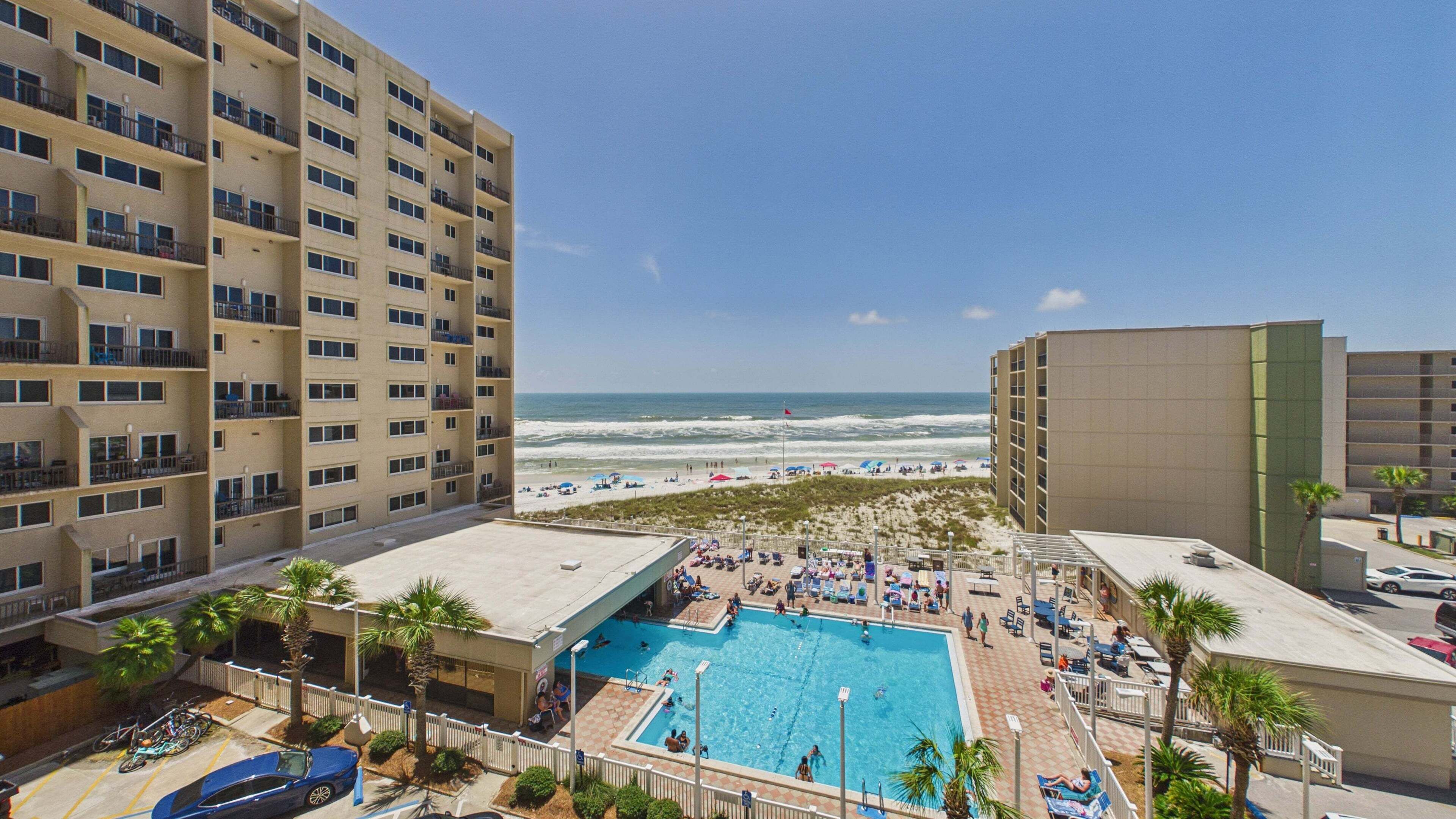 Un hôtel doté d’une piscine, offrant une vue sur la plage et disposant d’un parking.