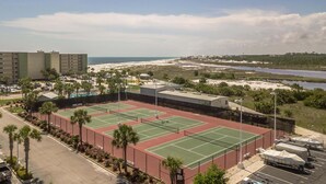 A tennis court with a parking area, a pool, and a view of the beach and water. - Pinnacle Paradise 336-Gulf Views-Sleeps 7 (Panama City Beach)