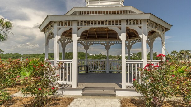 A white gazebo with a wooden roof, surrounded by flowering plants and a clear sky. - Pinnacle Paradise 336-Gulf Views-Sleeps 7 (Panama City Beach)