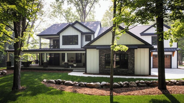 A modern two-story house with a stone foundation, a covered patio, and a well-maintained lawn. -  5 Min Walk to Beach + Game Room + Wood & Propane Fire Pits - Heatonelli Haven (South Haven)