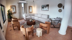 A living room with a sectional sofa, a coffee table, and a patterned rug. - Luxury 7-bedroom villa with Ocean Views & Pool in Mt. Irvine (Mt. Irvine)