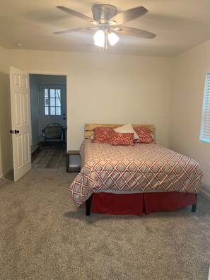 A bedroom with a bed, a ceiling fan, a door, and a window. - Awesome 3-bedroom house 1.5 miles to Lake Texoma & 5 miles to Megastar casino (Gordonville)