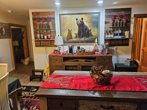 A cozy room with a wooden dresser, a television, and a shelf with various items. - Peaceful 2 bedroom cabin 4 Miles from Red Lodge perfect for relaxing getaways. (Roberts)