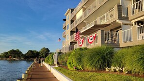 Ein Hotel am Wasserufer mit Balkonen, einer Holzterrasse und amerikanischen Flaggen.