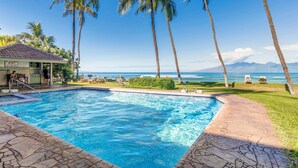 A swimming pool with a lifeguard station, lounge chairs, and a view of the ocean. - Oceanfront 1BR Condo Steps to Beach West Maui (Honokowai)