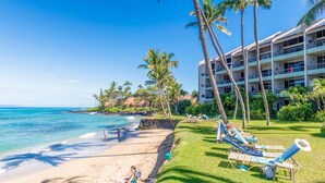 A beach resort with a pool area, palm trees, and a building with multiple balconies. - Oceanfront 1BR Condo Steps to Beach West Maui (Honokowai)
