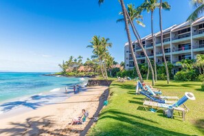 A beach resort with a pool area, palm trees, and a building with multiple balconies. - Oceanfront 1BR Condo Steps to Beach West Maui (Honokowai)