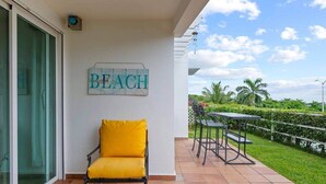Ein Balkon mit einem Stuhl, einem Tisch und einem Schild mit der Aufschrift 'BEACH'.