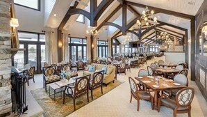 A spacious dining area with high ceilings and exposed beams, featuring multiple dining tables and chairs. - Private Resort Retreat Near Rehoboth Beach in Exclusive "The Peninsula" (Millsboro)
