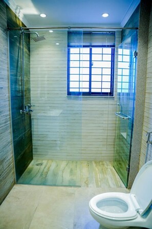 A modern bathroom with a glass-enclosed shower, a window, and a toilet. - Spacious 5BR, 2 kanal Luxury Family Home (Lahore)