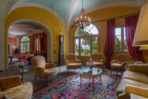 A spacious room with arched ceilings, a large chandelier, and multiple seating areas. - Villa Cirra - Country Villa with Private Pool (Lucca)
