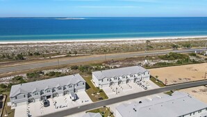 Zona residencial costera con casas, una playa y una carretera.
