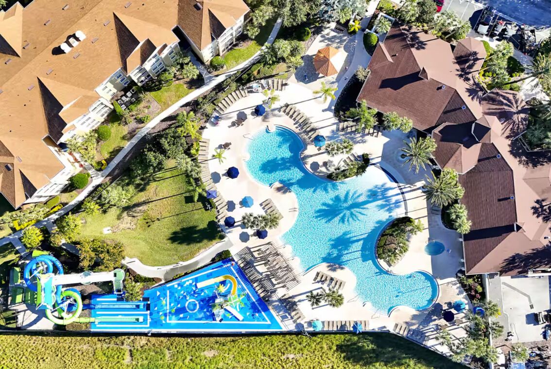 Vista aérea de un resort con varias piscinas, parque acuático y diversas zonas de estar al aire libre.