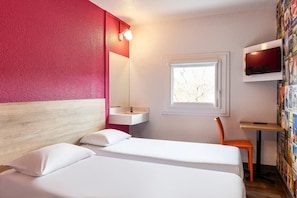 A hotel room with a bed, a small bedside table, a chair, a window, and a wall-mounted TV. - Hotelf1 Marne la Vallee Collegien (Collegien)
