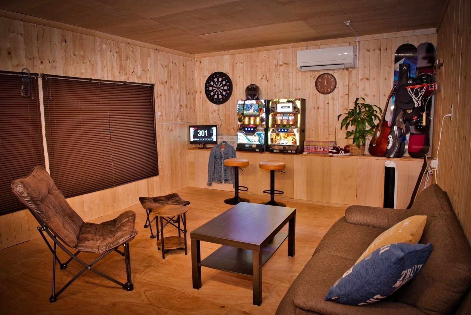 Ein gemütliches Zimmer mit Holzvertäfelung, einer Dartscheibe, einer Uhr und einer Jukebox.