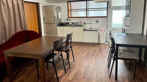 Una cocina compacta con comedor, un sofá rojo y una ventana con vistas.