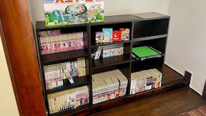 Una estantería con varios juegos de mesa y una caja de juego.