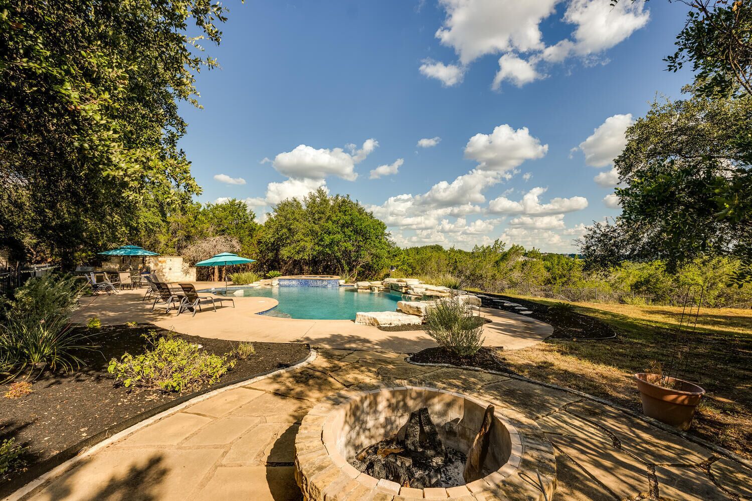 A backyard with a swimming pool, a fire pit, and outdoor furniture.