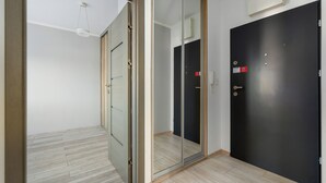 A room with a sliding glass door, a dark door, and a light wooden floor. - Raginisa Superior Apartment (Szczecin)
