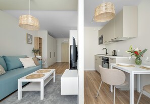 Ein modernes Wohnzimmer mit Sofa, Couchtisch und einem Essbereich mit Stühlen und Tisch.