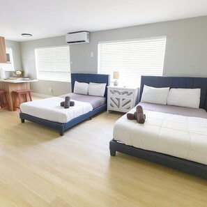 Habitación de hotel con dos camas, un escritorio y una ventana.