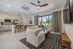Ein modernes Wohnzimmer mit Sofa, Couchtisch und Essbereich.