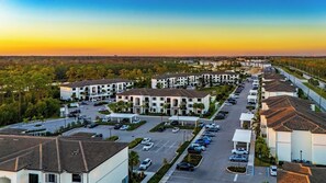 Un quartier résidentiel comprenant plusieurs immeubles d’appartements, un parking et une route.