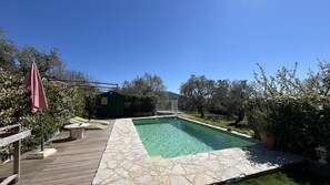 A clear swimming pool with a wooden deck and stone border, surrounded by greenery and a small shed. - Provencal house with private pool 2 persons (MONS)