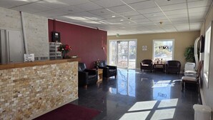 A reception area with a tiled counter, black leather seating, and a view of the outdoors.