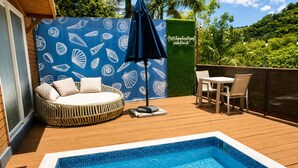 Zona junto a la piscina con un área de estar circular, una mesa y sillas, y una piscina pequeña.