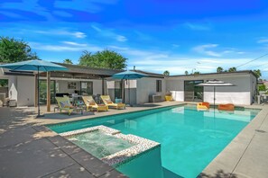 A swimming pool with lounge chairs and umbrellas, a hot tub, and a covered patio area. - Palm Springs Golden - Your Adventure Awaits! (Palm Springs)