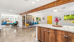 Una cocina moderna con armarios de madera, una encimera blanca y una lámpara colgante.