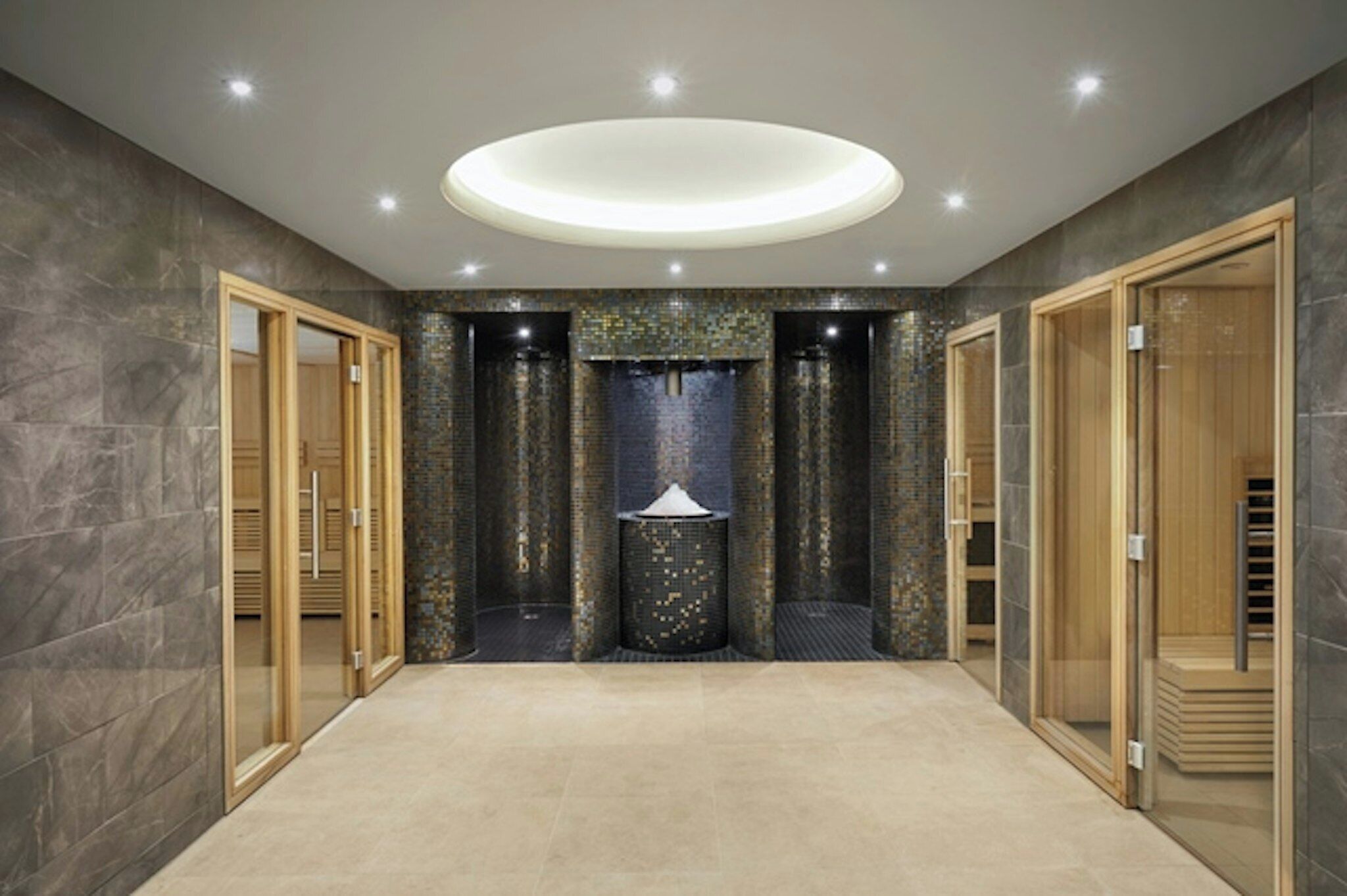 Un pasillo amplio con una columna decorativa central, puertas de madera y una lámpara de techo moderna.