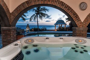 Ein Whirlpool mit Blick auf den Ozean und Palmen.