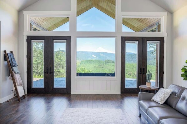 Une pièce spacieuse avec de grandes fenêtres, un plancher en bois et un canapé en cuir.