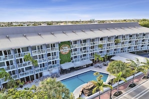 A hotel with a rooftop pool, outdoor seating, and a sign reading 'The Garden Hotel.' - Ocean Blvd King Suite Near the Beach! (Fort Lauderdale)
