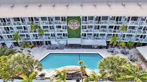 A hotel with a pool, outdoor seating, and a sign reading 'The Garden Hotel.' - Ocean Blvd Double Suite with Kitchenette at The Botanica! (Fort Lauderdale)