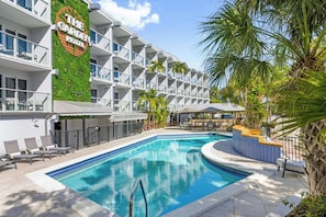Ein Hotel mit Pool, Sitzgelegenheiten im Freien und einem Restaurant namens 'The Greenhouse'.