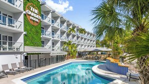 A hotel with a pool, outdoor seating, and a restaurant named 'The Greenhouse.'