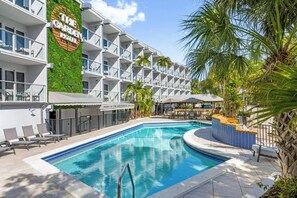 Ein Hotel mit Pool, Sitzgelegenheiten im Freien und einem Restaurant namens 'The Greenhouse'.