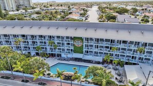 A hotel with a pool, outdoor seating, and a view of the surrounding area.