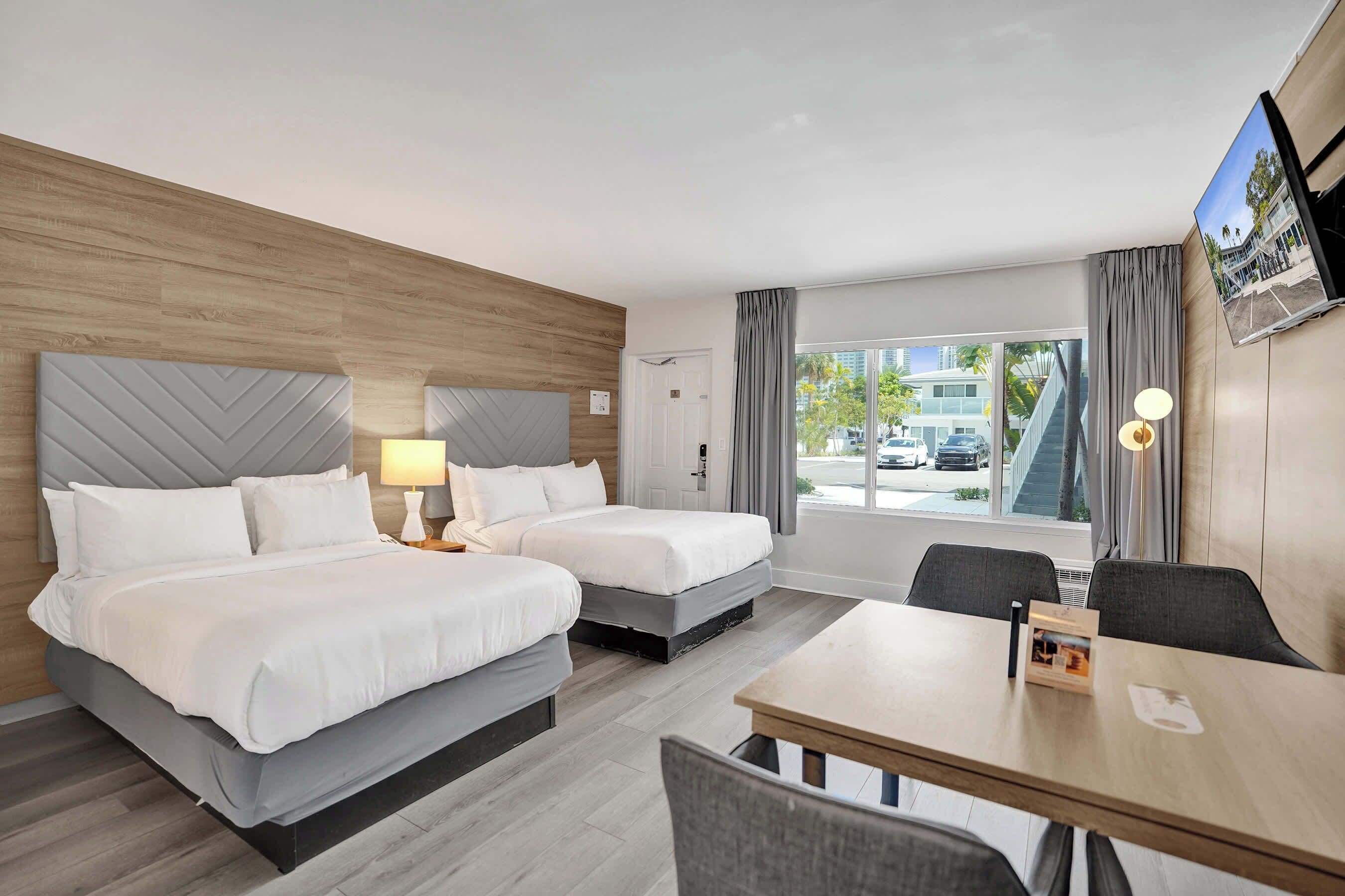 Bedroom with two beds, window, and smart TV