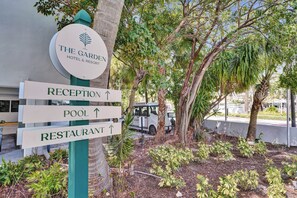 Señalización para The Garden Hotel & Resort con indicaciones hacia la recepción, la piscina y el restaurante.