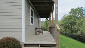 A wooden porch with a bench, a small step leading to the entrance, and a mailbox on the right. - Amazing View, EV Charger, Walk to Banner Elk (Banner Elk)