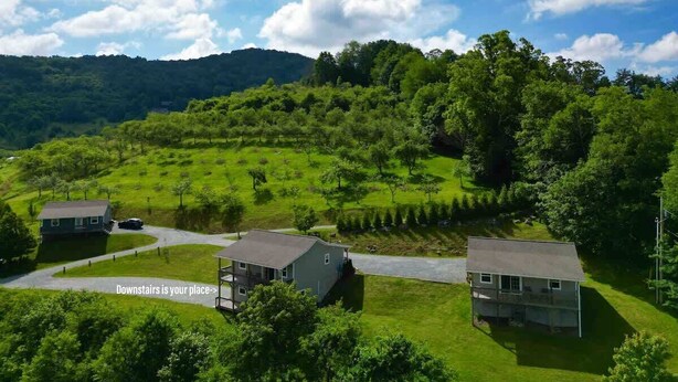 A rural landscape with three houses, a winding road, and a hilly backdrop. - Amazing View, EV Charger, Walk to Banner Elk (Banner Elk)