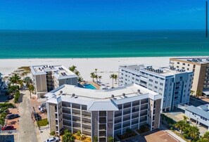A hotel with a pool, multiple floors, and a view of the beach and ocean. - 
NEW Gulf‑Front 2BR-2BA - Direct View of Pool-Beach-Gulf (Fort Myers Beach)
