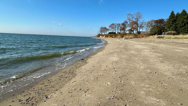 A beach with a clear sky, calm sea, and sparse vegetation. - Charming 3-bedroom beach cottage in beautiful Fairfield with AC (Fairfield)